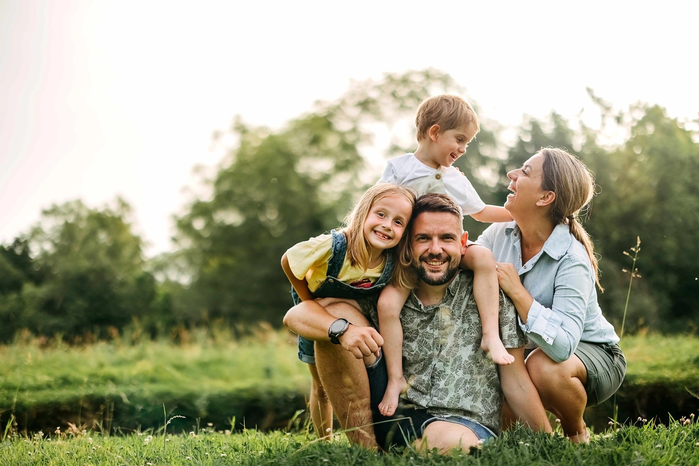 A family of four smiling happily

