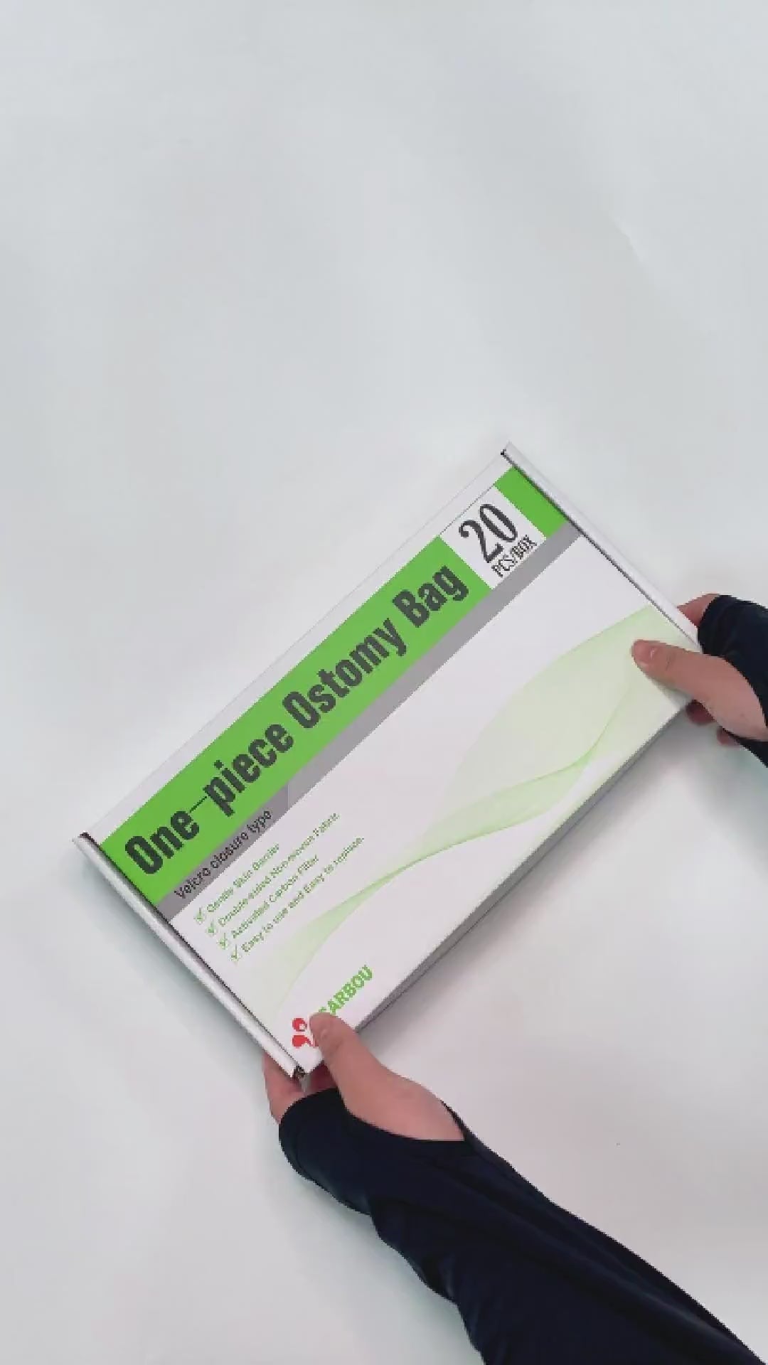 Hands unboxing a box of Carbou One-piece Ostomy Bags.