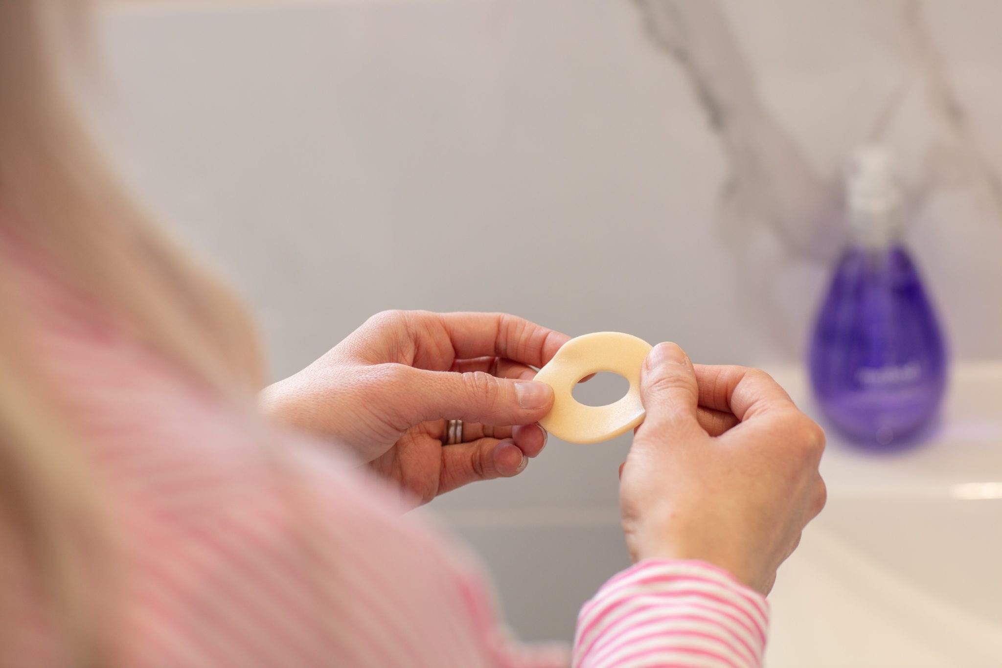 A woman is holding a ostomy ring
