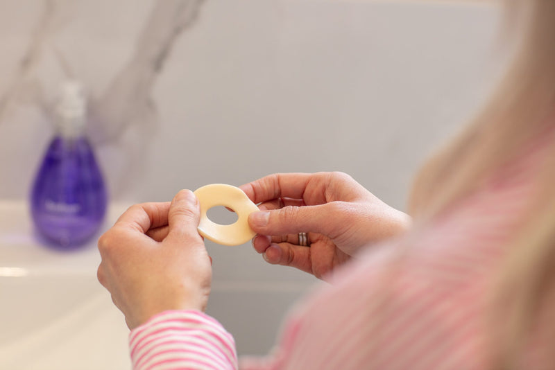 A woman is holding a ostomy ring